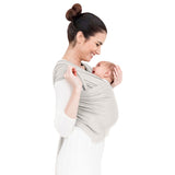 Fascia portabebè mhug Bamboo Wrap Milki color latte in morbidissima fibra 100% bamboo naturale indossata da modella con bambina di due mesi circa in posizione canguro in ripresa trequarti