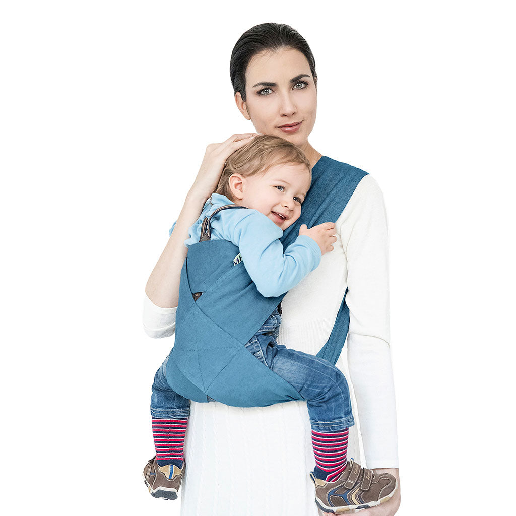 Portabebè Mhug Mikonos colore Carta da zucchero si indossa in un solo gesto come una T-shirt indossato da modella con bambino di circa quattordici mesi correttamente seduto in posizione a m visione frontale di trequarti