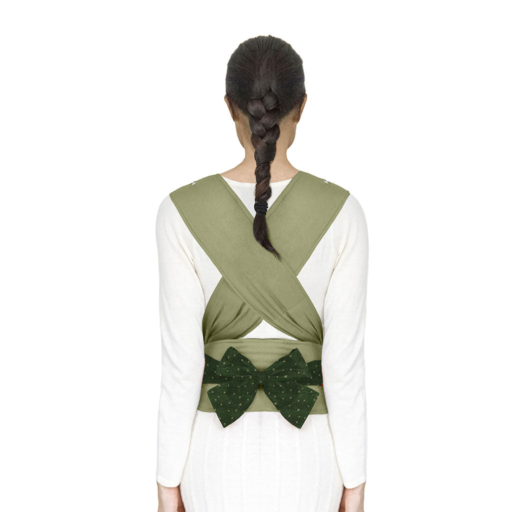 portabebè mhug mei tai collezione fantasia modello Sparkling fondo di base verde salvia con bavero fantasia verde bosco a stelline verde salvia bottoni a pressione verdi salvia indossato da modella con bambino di dodici mesi circa in ripresa retro dettaglio incrocio spallacci