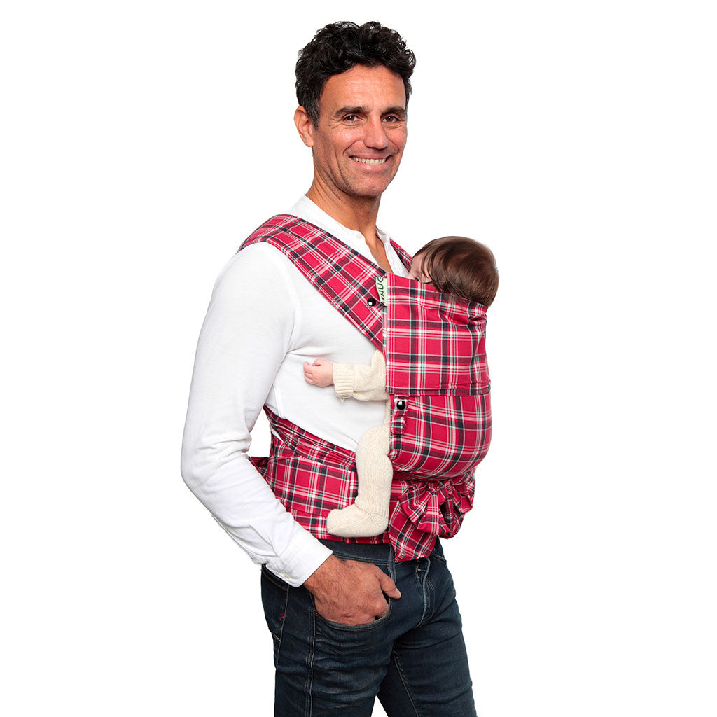 portabebè mhug mei tai collezione fantasia modello Total Scottish fondo di base rossa con righe nere bottoni a pressione neri indossato da modello con bambina di due mesi circa in posizione canguro in ripresa trequarti