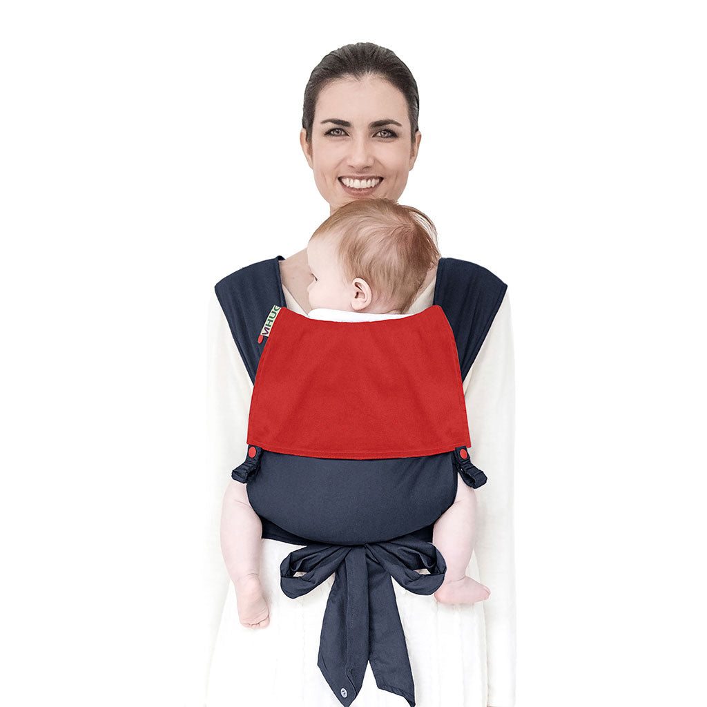 portabebè mhug mei tai collezione Bicolore modello  Yankee fondo di base blu con bavero rosso bottoni a pressione rossi indossato da modella con bambina di sei mesi circa in posizione canguro in ripresa frontale