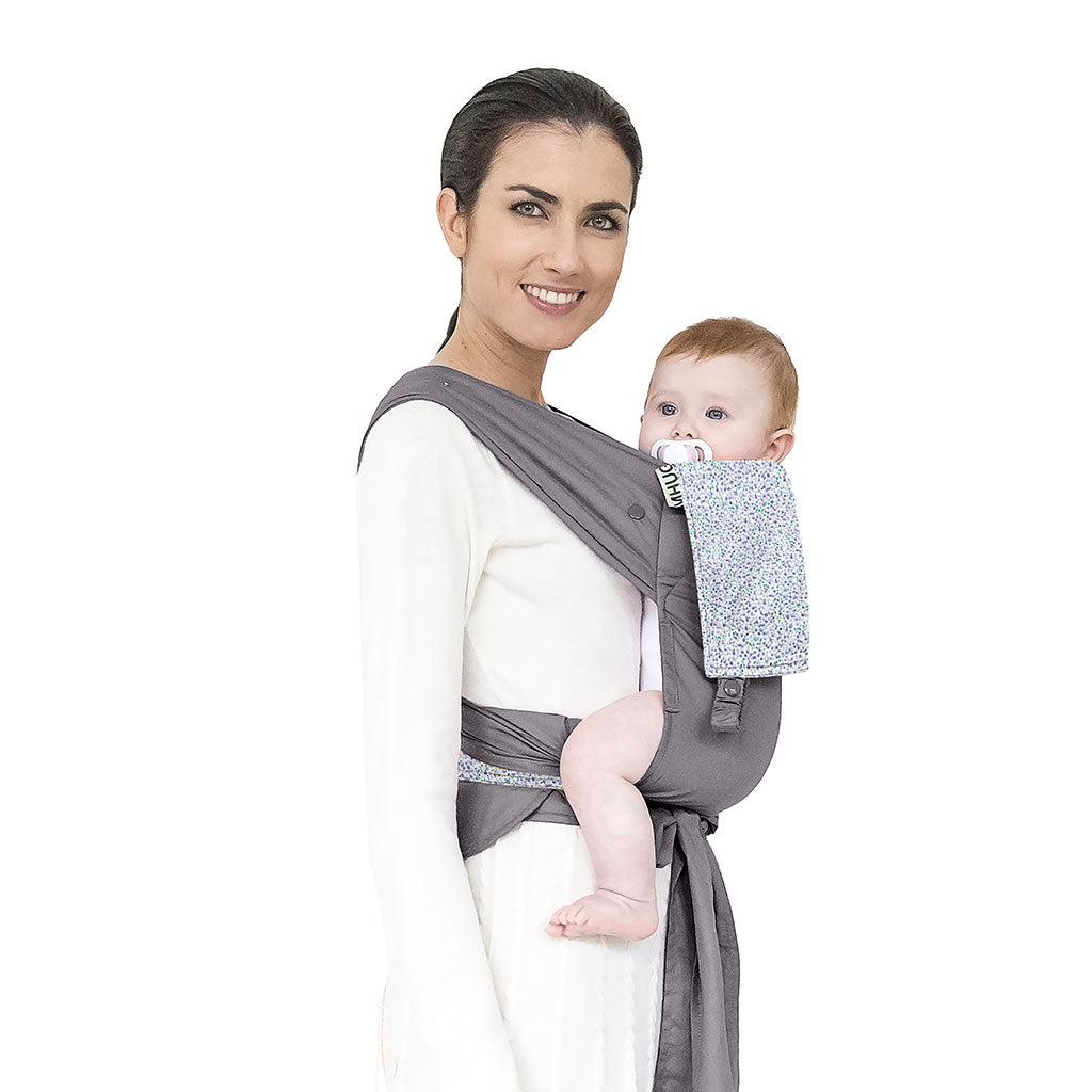 portabebè mhug mei tai collezione fantasia modello Blue Romantic fondo di base grigio con bavero fantasia fiorellini blu bottoni a pressione grigi indossato da modella con bambina di sei mesi circa in posizione canguro in ripresa trequarti