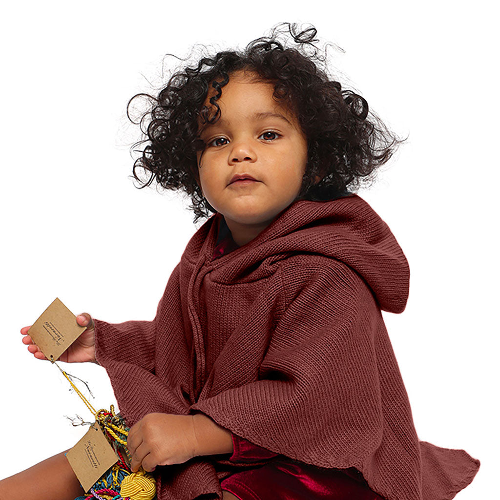 Mhug Poncho lana merino di colore castagna indossato da bebè di 10 mesi circa